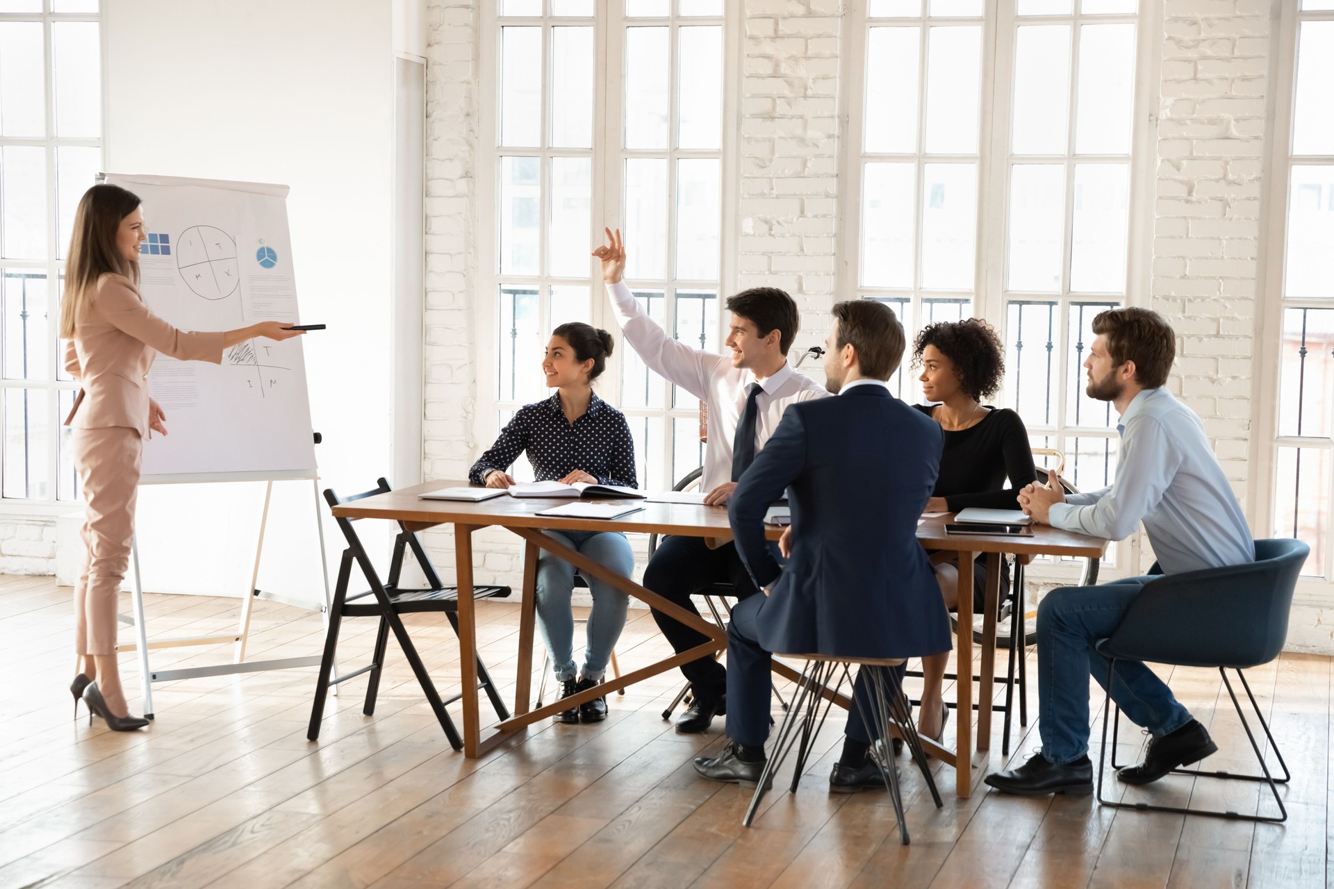 Diverse business intern audience asking question to speaker